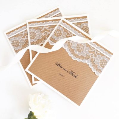 Rustic folded wedding invitations with lace and ribbon detail