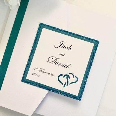 White and teal pocketfold with entwined hearts