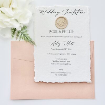 Handmade paper invitation with wax seal and blush pink envelope